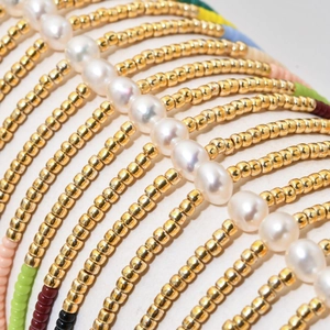 Multilayer Miyuki bead bracelet with white pearls and gold accents in bohemian style