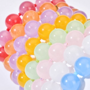 Pulseras de cuentas de piedra en vibrantes colores caramelo sobre un fondo blanco puro