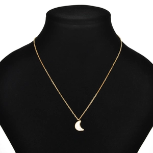Close-up of golden crescent moon crystal pendant necklace on a black mannequin