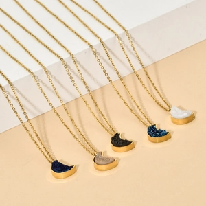 Macro view of crystal moon pendants in assorted colors on golden stainless steel chains