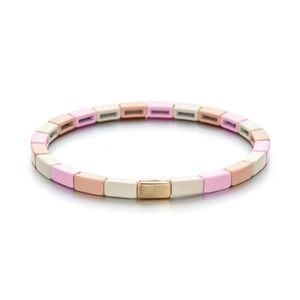 Detalle de cuentas rectangulares de esmalte rosa macarrón y oro en pulsera elástica