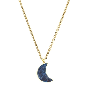 Close-up of golden moon pendant necklace with glittering dark blue stone on white background