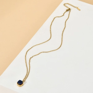 Detail of square gold pendant with deep blue druzy crystal on stainless steel chain