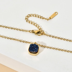 Detail of gold stainless steel necklace with blue square pendant and lobster clasp
