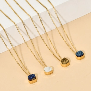 Detail showing various crystal moon pendants in blue and white on gold chains