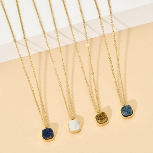 Detail of square druzy crystal pendants in gold chain necklaces with four vibrant colors