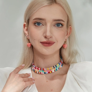 Three-layer colorful beaded choker and gold heart drop earrings on a female model