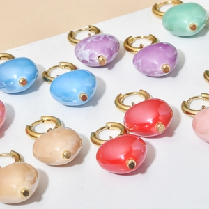 Colorful heart drop earrings with gold huggie hoops in various candy tones