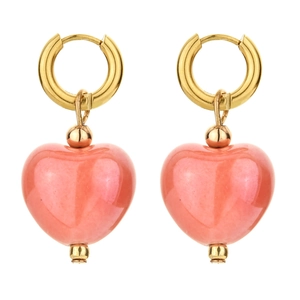 Detailed macro view of golden hoop earrings featuring peach heart-shaped ceramic pendants