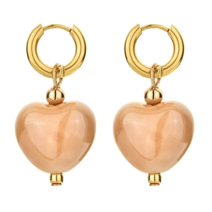 Close-up of heart shaped ceramic pendant earrings with gold hoops and polished finish