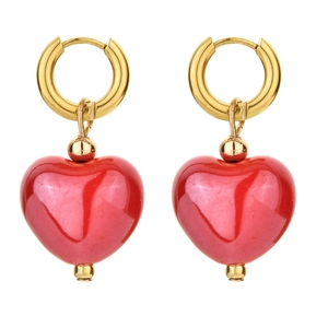 Detail view of heart-shaped red ceramic charms on gold earrings with high gloss finish