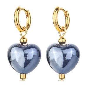 Detail of gold heart earrings with shiny deep blue enamel pendants on white background