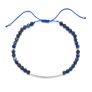 Detailaufnahme dunkelblauer Edelsteinperlen mit silbernem Rohr auf blauem Kordelarmband