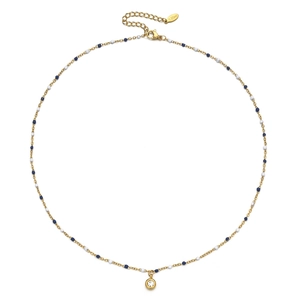 Macro-opname van gouden roestvrijstalen ketting met blauwe kralen en zirkoon hanger