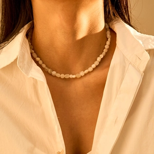 Detailopname van onregelmatige witte halfedelstenen kralenketting op een model