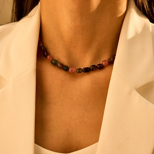 Bohemian veelkleurige halfedelsteen kralenketting gedragen op een witte blazer