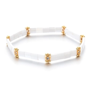 Close-up of bohemian white Tila tile bracelet with gold beads and sparkling zircon stones