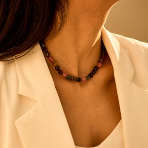 Detail van kleurrijke toermalijn edelsteenkralen op een bohemien ketting