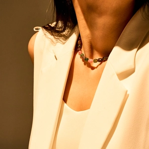Detailopname van de bohemien veelkleurige halfedelsteen kralenketting om de nek van het model