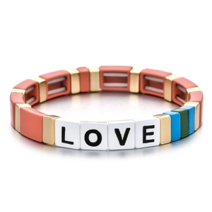 Détail des perles lettres LOVE et des perles en émail coloré sur bracelet doré