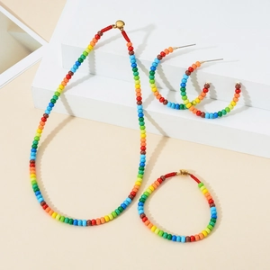 Colorful mixed bead jewelry set including a necklace, bracelet, and round hoop earrings