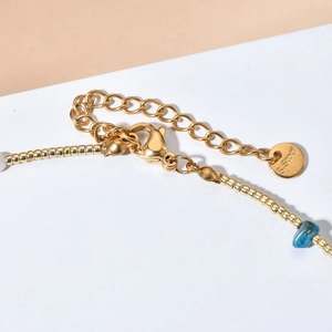 Macro shot of stainless steel clasp and blue raw stone on a pearl beaded necklace