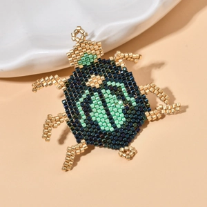Handcrafted MIYUKI seed bead beetle pendant with green and gold metallic finish