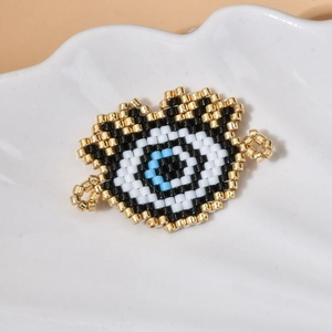 Macro detail of handmade MIYUKI bead Evil Eye charm with blue and gold weave for jewelry