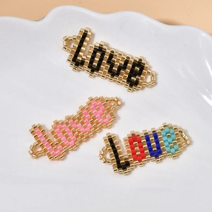 Handmade woven MIYUKI seed bead LOVE charms in three colors on a ceramic plate