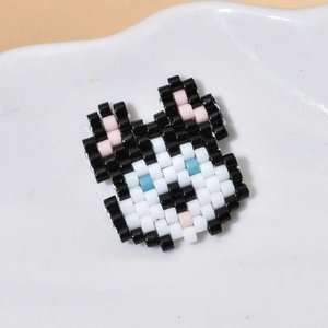 Dettaglio di un ciondolo animale in perline stile Kuromi su un piatto di ceramica