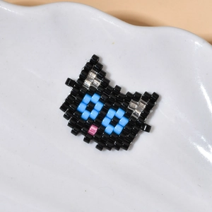 Vista macro di un ciondolo a forma di gatto in perline pixel fatto a mano su ceramica