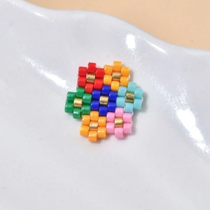 Colorful MIYUKI beaded flower cluster charms for DIY jewelry making in a white ceramic dish