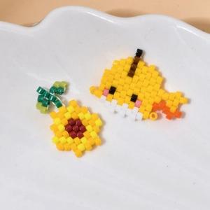 Detail of handmade MIYUKI seed bead charms featuring cute yellow chick and sunflower designs