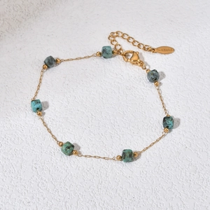 Gold stainless steel chain bracelet featuring seven turquoise style stone cube beads