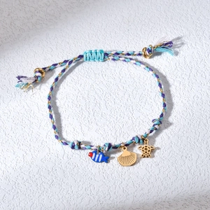 Detail of woven ocean bracelet with blue fish, golden scallop and sea turtle charms