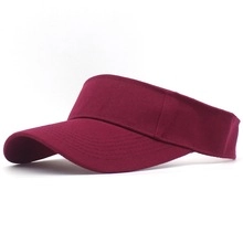 Detail of burgundy cotton sun visor hat with curved brim and adjustable strap closure