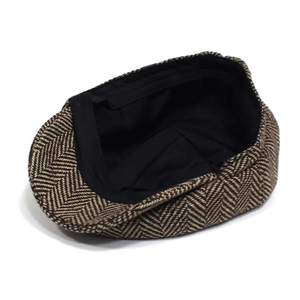 Dettaglio del berretto newsboy in tweed marrone con fodera interna nera