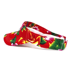Detail of red floral visor hat featuring colorful ethnic patterns and white stitching
