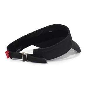 Macro detail of adjustable velcro strap and red logo tag on black cotton visor hat