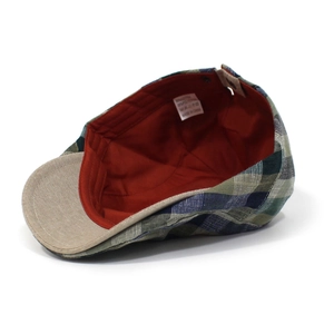Detail view of cotton blend checkered flat cap featuring red lining and washing label