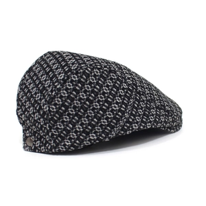 Close-up of black and grey jacquard denim flat cap with vintage bronze side button detail