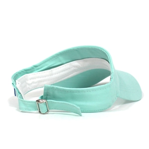 Detail view of the mint green cotton sun visor featuring an adjustable metal buckle strap