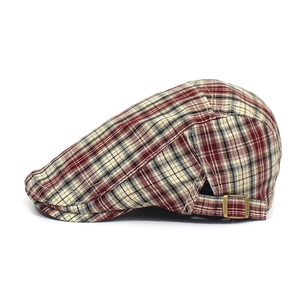Detailed side view of checkered ivy cap with adjustable bronze metal buckle