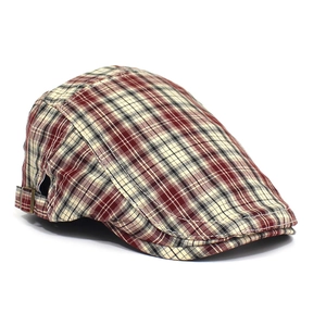 Detailed side view of vintage plaid beret hat with adjustable metal buckle on white background