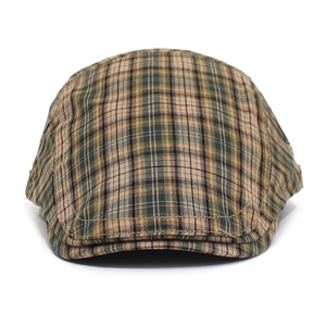 Detail shot of the vintage plaid flat cap fabric with orange stitching accents