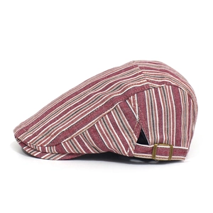 Detail of adjustable bronze metal buckle and striped cotton fabric on a vintage flat cap