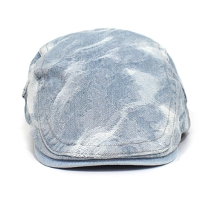 Detail of light blue washed denim beret featuring vintage distressed camouflage patterns