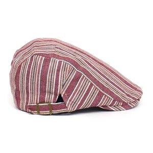 Detail view of adjustable bronze buckle and vintage striped fabric texture on flat cap