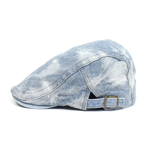 Detail view of washed denim ivy cap featuring metallic adjustment buckle and textured fabric