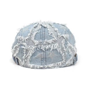 Detail einer hellblauen Denim-Docker-Mütze mit Sternenmuster und Used-Look-Effekt